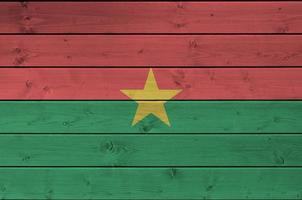 Burkina Faso flag depicted in bright paint colors on old wooden wall. Textured banner on rough background photo