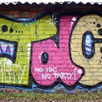 fragmento de dibujos de graffiti. la antigua muralla decorada con manchas de pintura al estilo de la cultura del arte callejero. textura de fondo de color foto