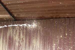 Washing off dirt from fence. Water flow to jet of water. photo