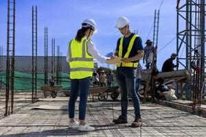 Team of engineering architect inspector and contractor having discussion while examining the quality of construction work of real estate development project concept photo
