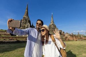 Couple of foreign tourists take selfie photo at Wat Phra Si Sanphet temple, Ayutthaya Thailand, for travel, vacation, holiday, honeymoon and tourism