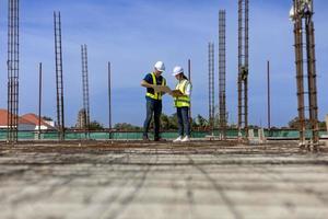 Team of engineering architect inspector and contractor having discussion while examining the quality of construction work of real estate development project concept photo