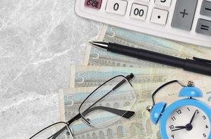 5 euro bills and calculator with glasses and pen. Business loan or tax payment season concept. Time to pay taxes photo