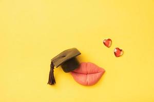 Lips with a graduated cap and small hearts. Relationship education concept photo