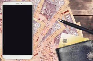 10 Indian rupees bills and smartphone with purse and credit card. E-payments or e-commerce concept. Online shopping and business with portable devices