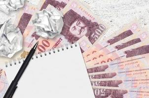 500 Hungarian forint bills and balls of crumpled paper with blank notepad. Bad ideas or less of inspiration concept. Searching ideas for investment photo