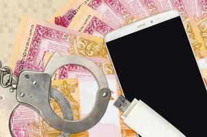 20 Belorussian rubles bills and smartphone with police handcuffs. Concept of hackers phishing attacks, illegal scam or malware soft distribution photo