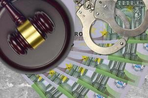 100 Euro bills and judge hammer with police handcuffs on court desk. Concept of judicial trial or bribery. Tax avoidance photo
