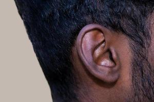 oído humano: el primer plano de la oreja de un hombre, su parte del cuerpo, ayuda a escuchar las ondas sonoras. foto