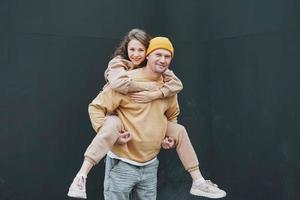 Stylish young family couple in love hipsters against black wall photo