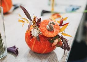 DIY autumn flower arrangement bouquet in the pumpkin at floristry studio photo