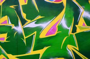 Fragment of graffiti drawings. The old wall decorated with paint stains in the style of street art culture. Colored background texture photo