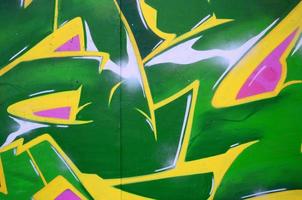 Fragment of graffiti drawings. The old wall decorated with paint stains in the style of street art culture. Colored background texture photo