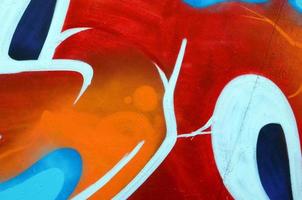 Fragment of graffiti drawings. The old wall decorated with paint stains in the style of street art culture. Colored background texture photo