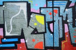Fragment of graffiti drawings. The old wall decorated with paint stains in the style of street art culture. Colored background texture photo