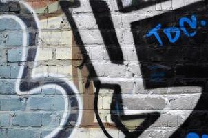Fragment of graffiti drawings. The old wall decorated with paint stains in the style of street art culture. Colored background texture photo