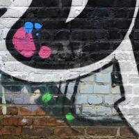 Fragment of graffiti drawings. The old wall decorated with paint stains in the style of street art culture. Colored background texture photo