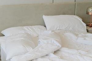 Unmade bedding sheets and pillow. Unmade messy bed after comfortable sleep concept photo