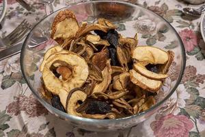 Close up of mixed dried fruit, prunes and sliced apples at the bowl on the table. Seasonal food photo