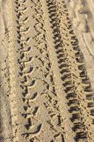 Traces of different car tires on the sand of the sea beach. Close up photo