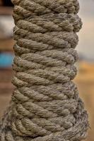 reeled rope on the coil. The texture of a rope. Thick brown rope rolled into a roll. Vertical layout. Background texture photo