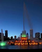 Buckingham Fountain at dusk lit in green and gold. photo