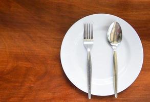 plato vacío con cuchara tenedor en la mesa de comida fondo de madera plato plato vacío foto
