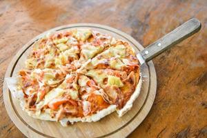 Rebanada de queso de pizza en bandeja de madera y servida en una mesa de madera, vista superior pizza de repostería casera italiana se cocina comida tradicional foto