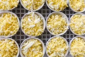 queso en tazón blanco - queso cheddar rallado para comida cocinada foto