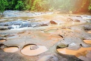 Landscape river stream waterfall in the green forest nature jungle water from mountain with rocks on sunny day photo