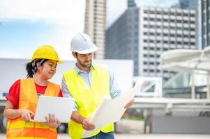 Two builder Engineer technician Business Team discuss plan at new construction site. photo