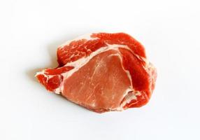 vista superior de cerdo, carne o ternera fresca en rodajas aislado sobre fondo blanco. endecha plana de alimentos crudos. pieza fresca de bistec preparado para parrilla o frito. foto