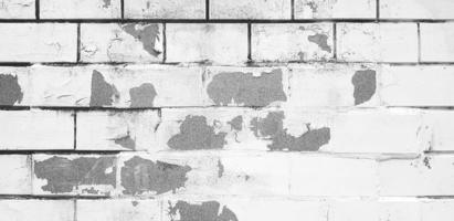 pared de ladrillo pintada agrietada para el fondo en tono blanco y negro. línea de patrón de papel tapiz en tono monocromático. exterior dañado y herido. estructura sucia o desordenada del hogar o la casa. foto