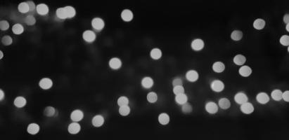 Blurred gray or grey Bokeh of light on dark or black background in monochrome style. Lighting blurry wallpaper. Festival or Celebration and Art of abstract concept. photo