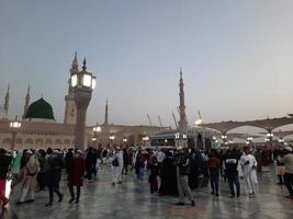 medina, arabia saudita, diciembre de 2022 - hermosa vista nocturna en masjid al-nabawi, los visitantes son vistos en las luces de la mezquita en las instalaciones de la mezquita. foto