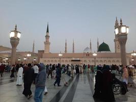 Medina, Saudi Arabia, Dec 2022 - Beautiful evening view in Masjid al-Nabawi, Visitors are seen in the lights of the mosque in the premises of the mosque. photo