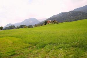 Travel to Sankt-Wolfgang, Austria. The green meadow with the houses in the mountains. photo