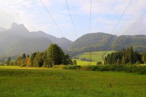 viaje a sankt-wolfgang, austria. la vista sobre el prado verde con las montañas al fondo. foto