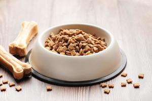 A bowl of dog food on a wooden floor. photo