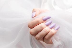 Girl's hands with a soft purple manicure. photo