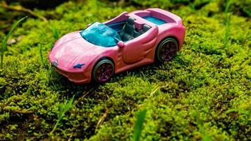 Minahasa, Indonesia  saturday, 10 December 2022, a toy car on green mossy ground photo