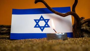 Israeli flag and candles burning in front of it, Holocaust memory day photo