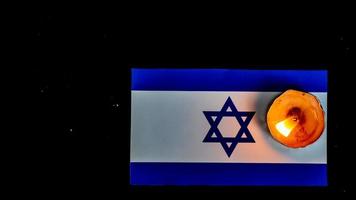 Israeli flag and candles burning above it, Holocaust memory day photo