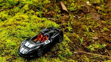 Minahasa, Indonesia  saturday, 10 December 2022, a toy car on green mossy ground photo