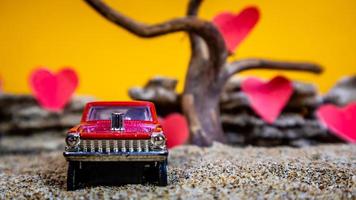 Minahasa, Indonesia December 2022, toy car with gradient orange background and a heart photo