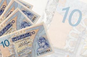 10 Tunisian dinars bills lies in stack on background of big semi-transparent banknote. Abstract business background photo