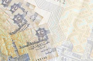 25 Egyptian piastres bills lies in stack on background of big semi-transparent banknote. Abstract business background photo