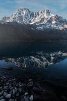 Snow-capped mountain and its reflection in the still water lake called Gokyo lake. Located deep in the Himalayas, within the border of Nepal, the tranquil Gokyo village is established around the lake. photo