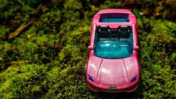 minahasa, indonesia sábado, 10 de diciembre de 2022, un coche de juguete en suelo verde cubierto de musgo foto