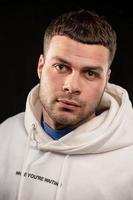 Portrait of a worried young man wearing a white hoodie photo